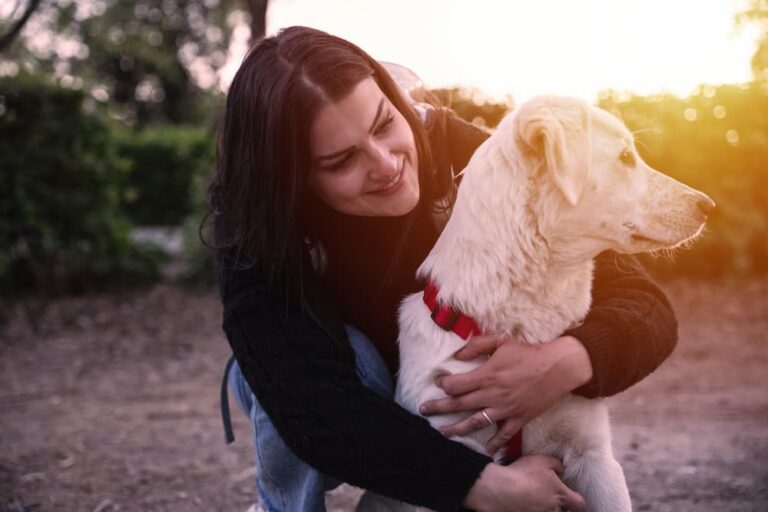 Young woman at the park at sunset with her four legged friend